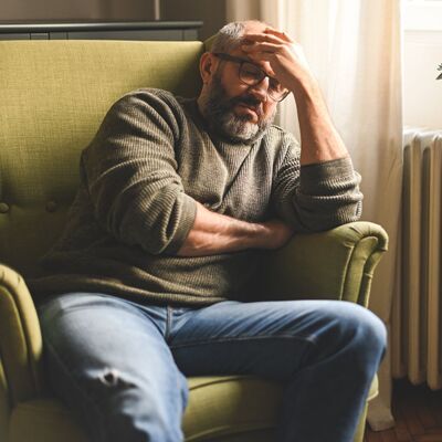 A man sitting in a chair and dealing with a lot of stress